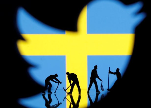 Small toy figures are seen through 3D printed Twitter logo in front of displayed Sweden flag in this illustration picture